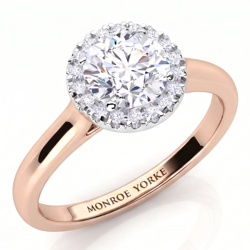 Oasis rose gold engagement ring, round centre diamond inside a halo of small diamonds on a plain band.