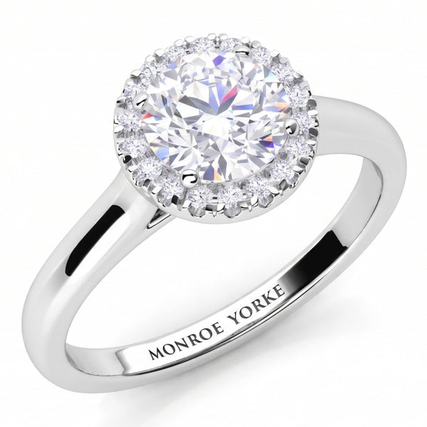 Oasis engagement ring in white gold or platinum, round diamond halo above a plain band.