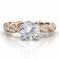 Quinn engagement ring in rose gold. Round brilliant centre diamond above a braided pave-set band.