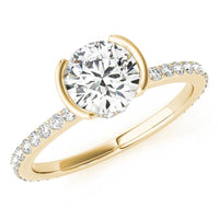 Riley half rub-over engagement ring in yellow gold, showing the two ends of the band closing over the sides of the round diamond