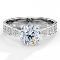 Sophia - A white gold or platinum diamond engagement ring with a round-cut center stone in a 4 claw setting and pavé-set side stones, shown on a clean white background. 