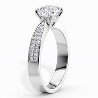 Sophia - White gold or platinum  diamond engagement ring with a round-cut center stone and a pavé-set diamond accent along the band, shown on a clean white background.