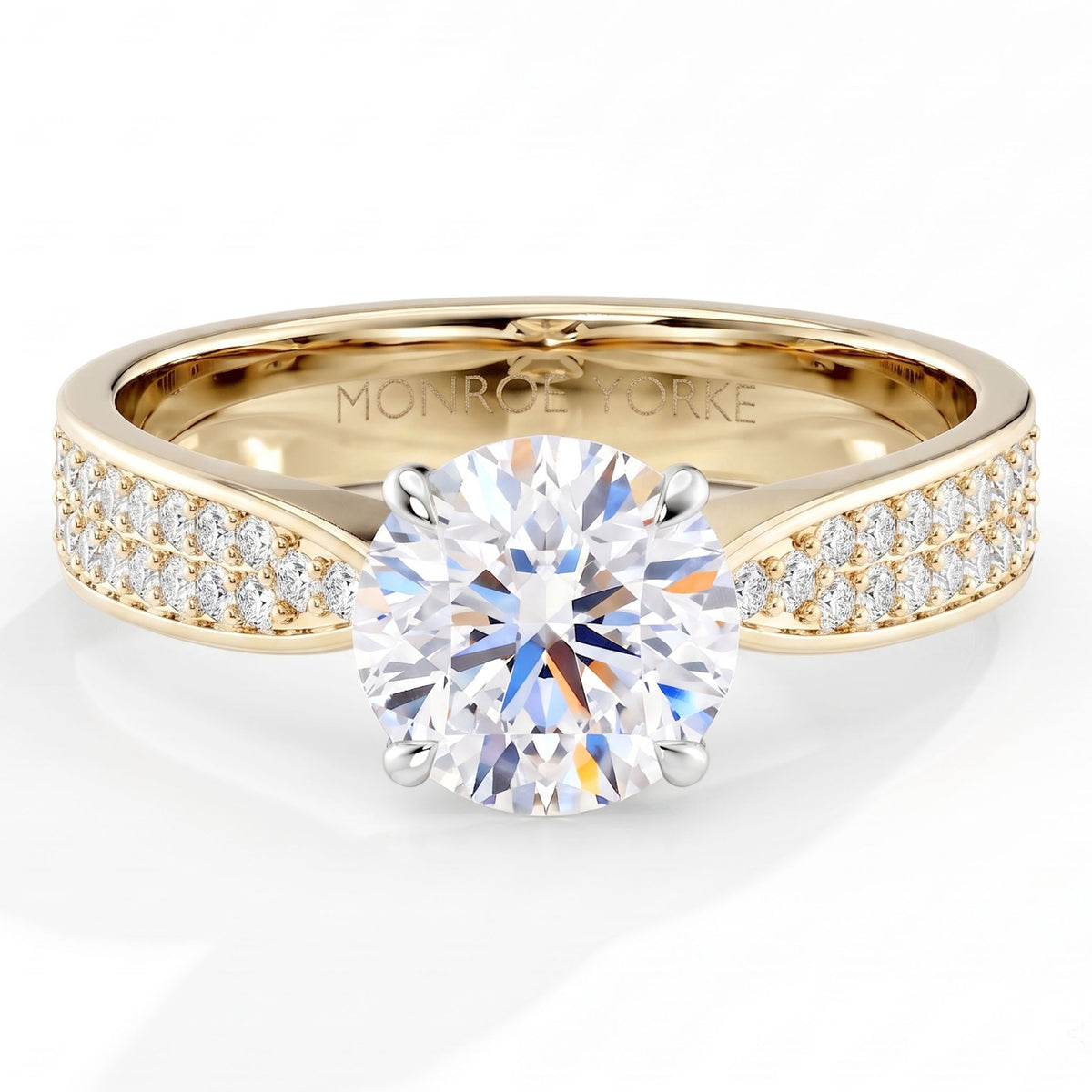 Sophia - A yellow gold solitaire engagement ring featuring a round brilliant-cut center stone and pavé-set side stones, with the brand name . 4 Claw centre setting