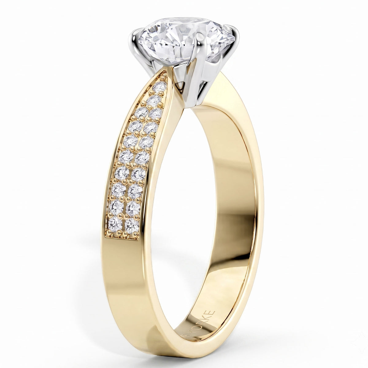 A yellow gold solitaire engagement ring with a pavé-set row of clear stones on the shank, featuring a brilliant-cut diamond center stone in a silver-colored prong setting, shown on a white background.