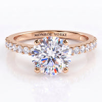 Spring - a rose gold engagement ring featuring a round brilliant-cut center diamond and a pavé-set diamonds on the band engraved with 'MONROE YORKE', 