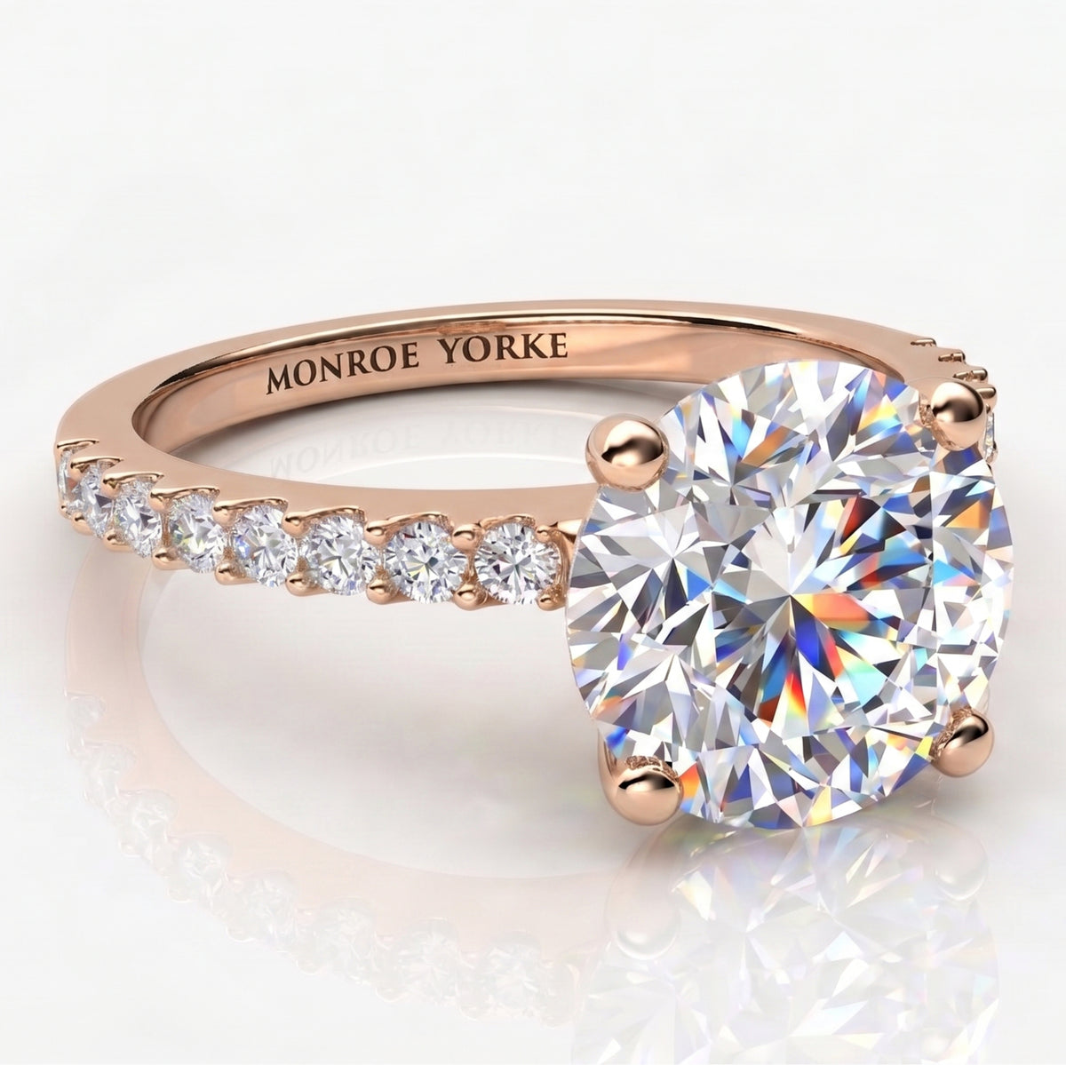 Rose gold diamond engagement ring with a large round-cut center stone and a pavé band.