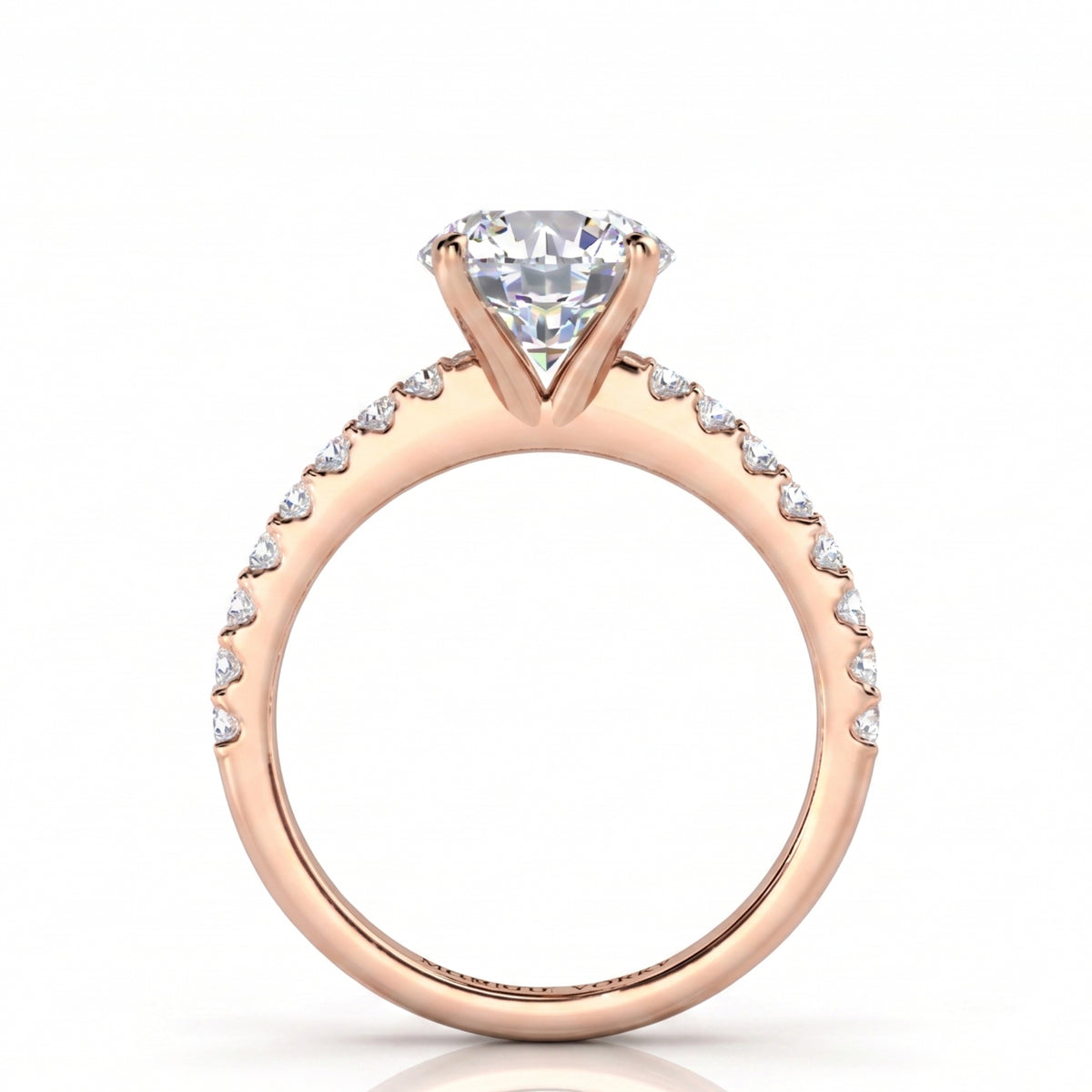 A rose gold engagement ring with a 4 claw centre setting and  a pavé set band of small diamonds