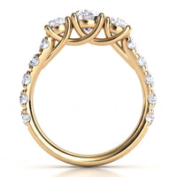 A yellow gold ring with a three-stone cluster setting and pavé-set round diamonds on the band.