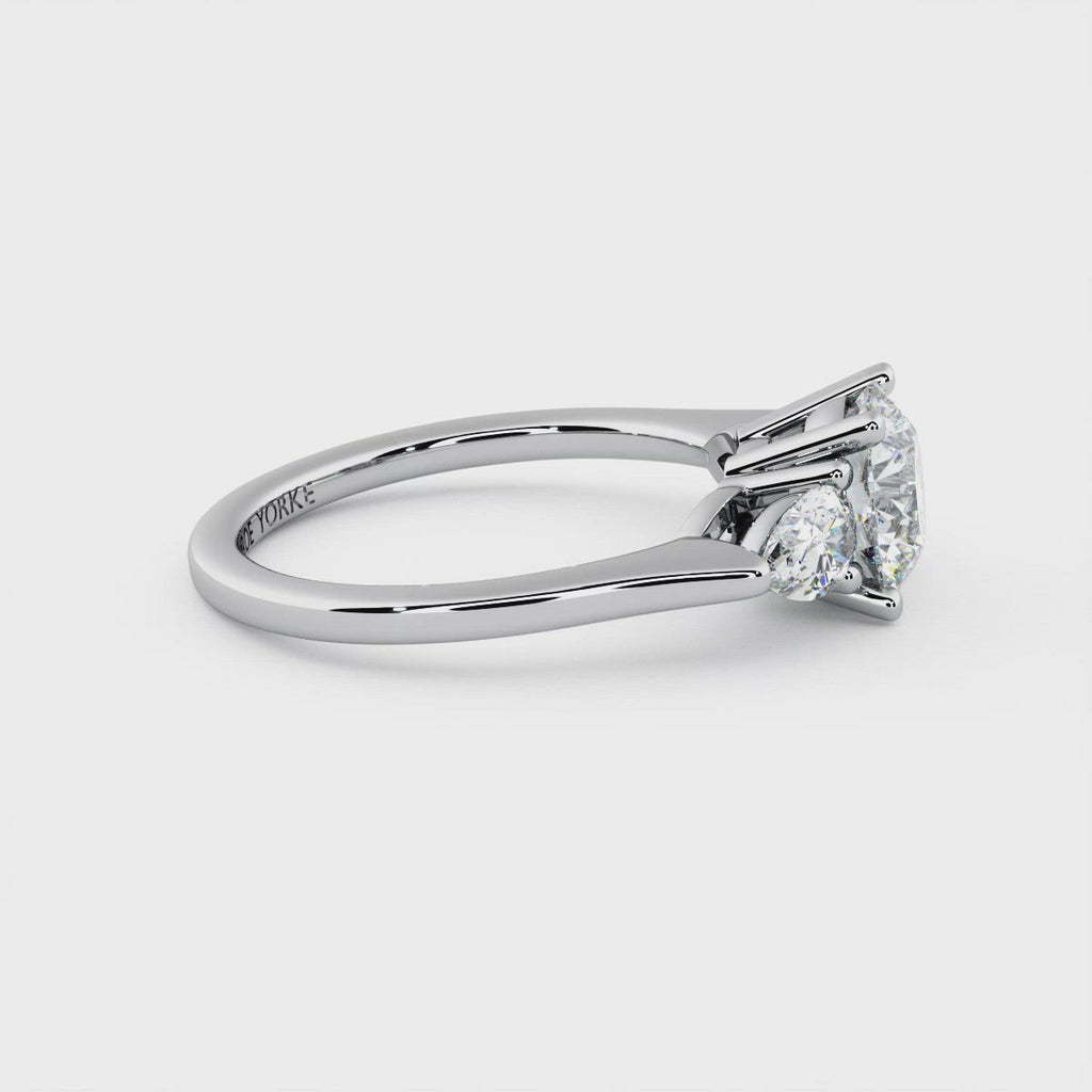 Diamond trilogy ring with a centre round diamond and pair cut diamonds.