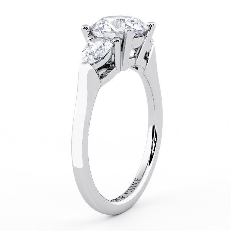Diamond trilogy ring with a centre round diamond and pair cut diamonds.