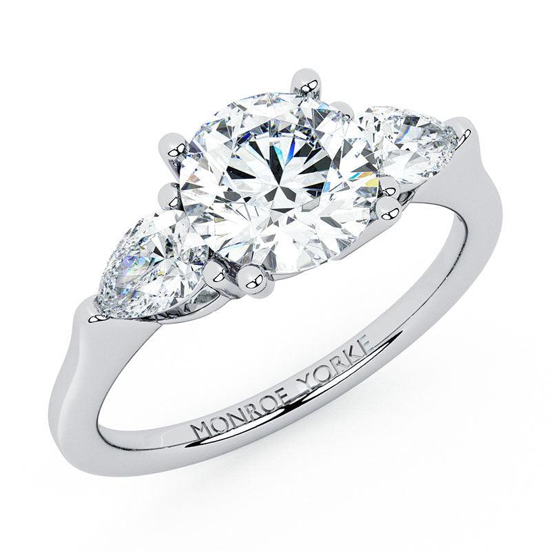 Adele - diamond trilogy ring with a centre round brilliant cut diamond and pear cut diamonds on side.  18ct white gold. 