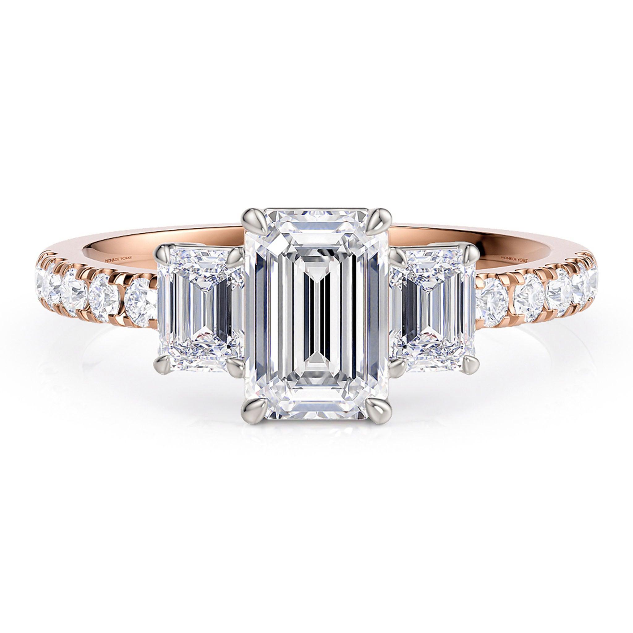 Aspen - emerald cut three diamond ring in rose gold.  Diamond set band in rose gold.  Centre setting where the 3 emerald cut diamonds are set are in white gold.  