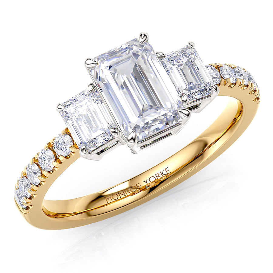 Aspen emerald cut diamond trilogy ring in gold. 18ct gold band and white gold centre setting. 