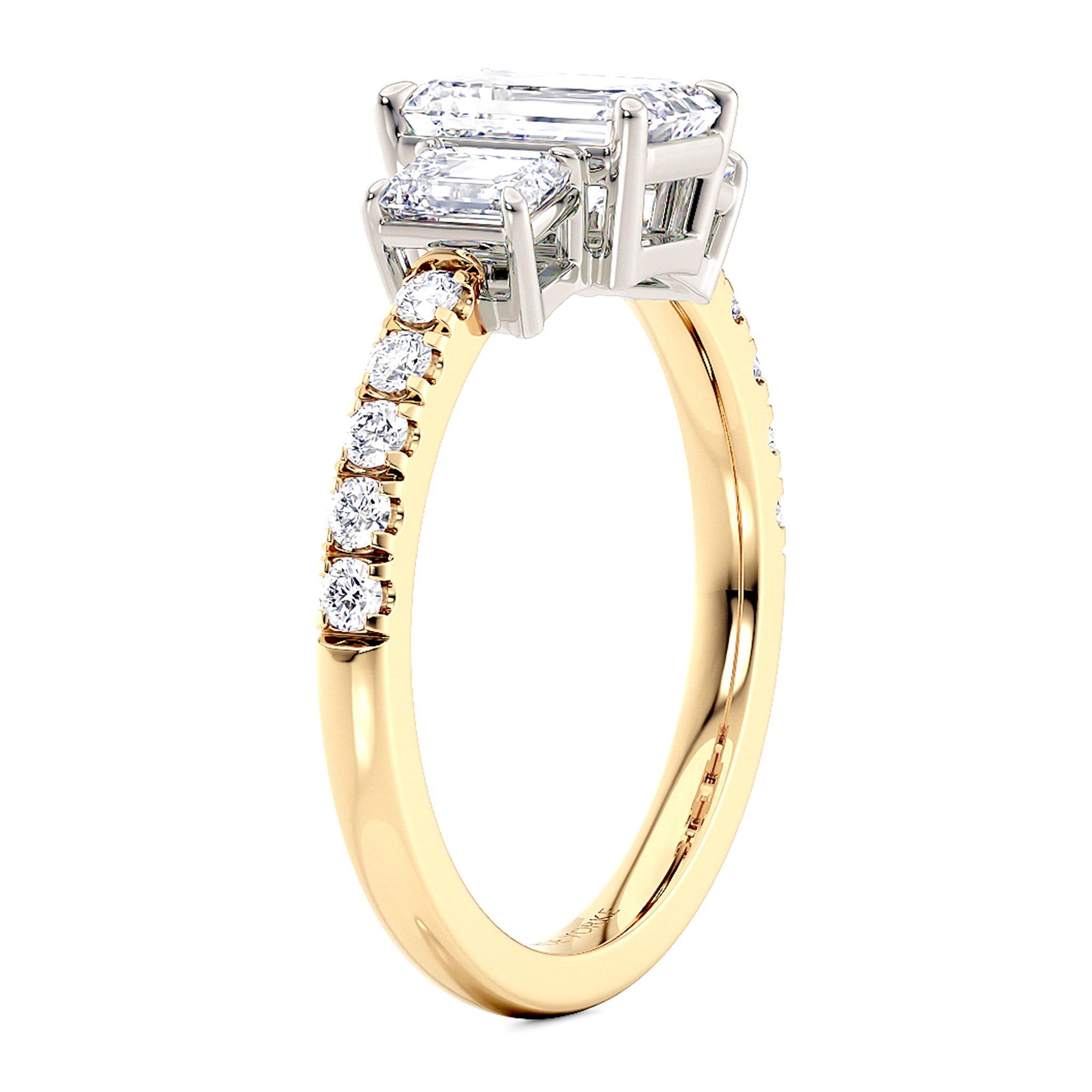 Adele emerald cut diamond three stone ring in gold with diamonds on the band