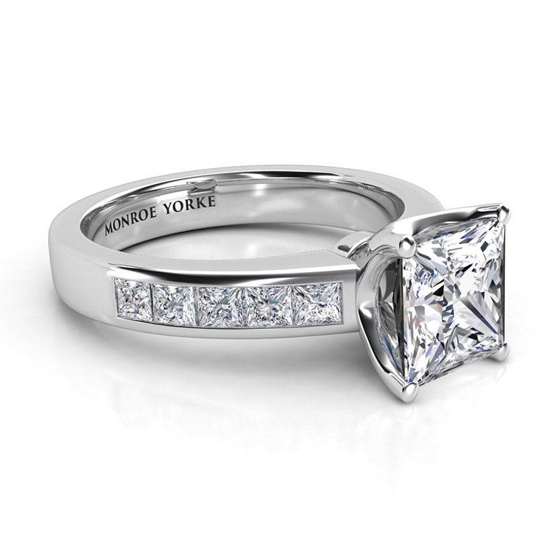 Albany White Gold.  Side view. princess cut diamond centre with channel set princess cut diamonds on the band. 