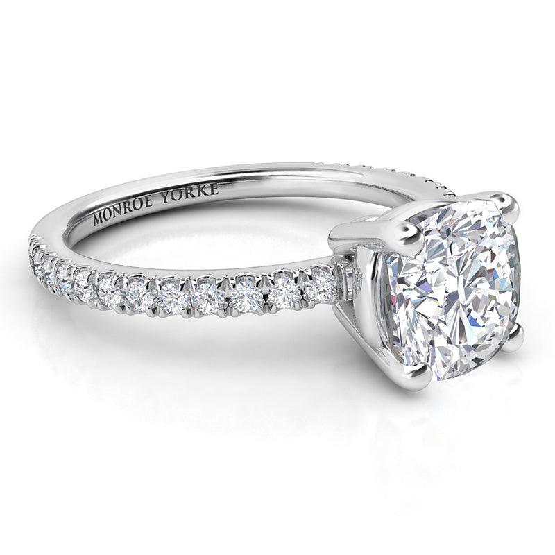 Blake - Side view showing centre cushion cut diamond in a basket setting and diamond set band in platinum.