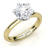 Six claw solitaire round diamond engagement ring. Yellow gold band and white fold centre setting. Calais