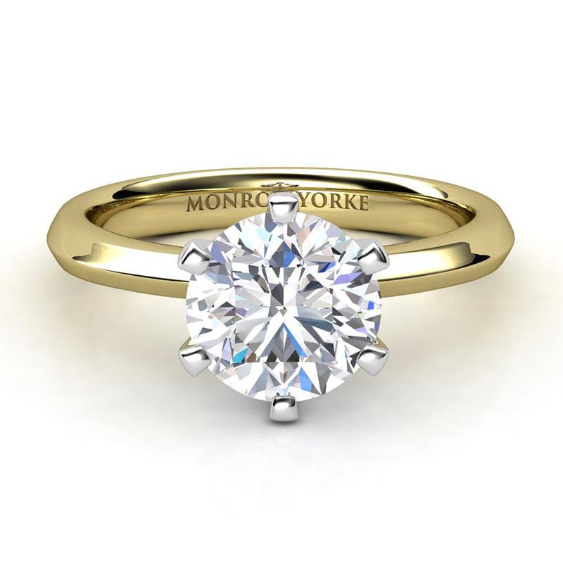 Six claw solitaire round diamond engagement ring. Yellow gold band and white fold centre setting. Calais Front view. 