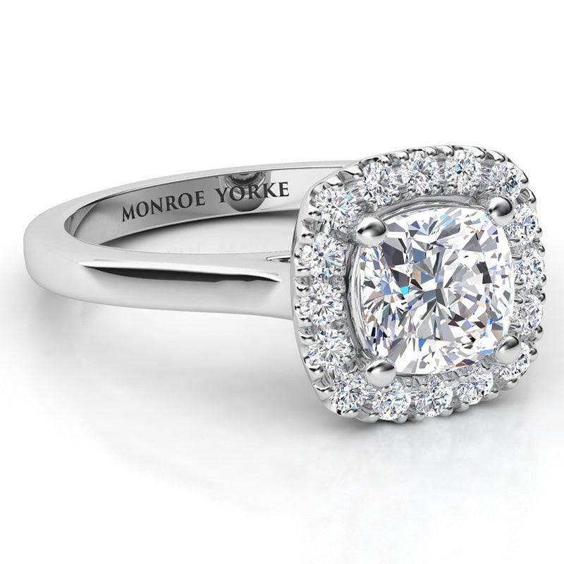 Carina - GIA certified cushion cut halo diamond engagement ring in platinum.  Halo of round diamonds set around the main diamond. Side view. 