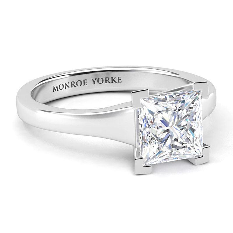 Princess cut solitaire diamond ring, centre v-claw setting. Chester in platinum. Side view showing tapered band