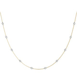 Diamond station necklace in yellow gold chain, white gold setting. 