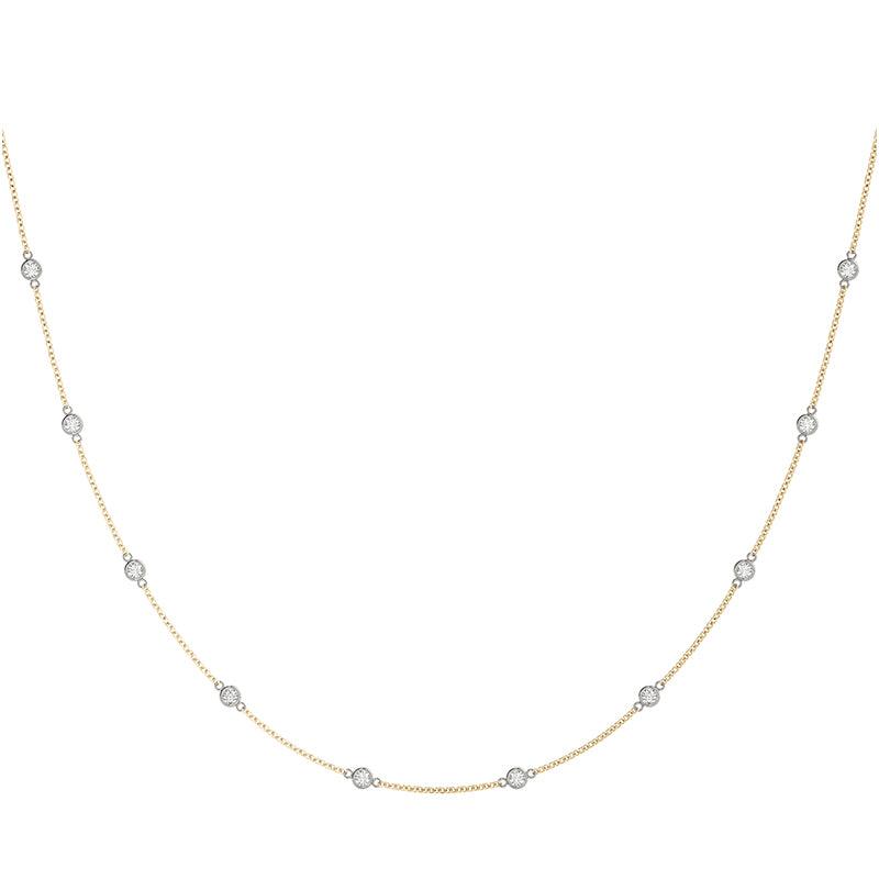 Diamond station necklace in yellow gold chain, white gold setting. 