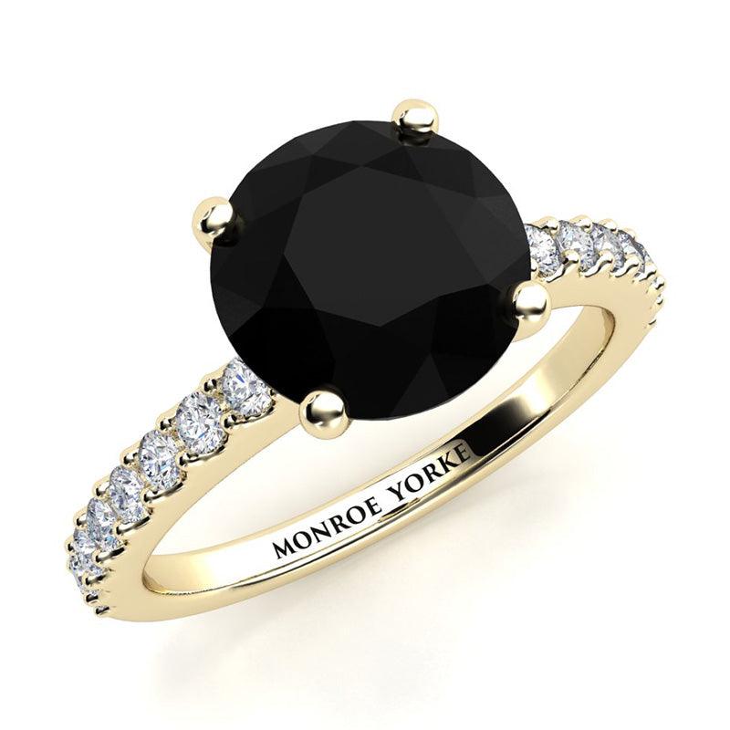 Desir - Yellow Gold black diamond engagement ring. 1.50 carat round black diamond. White diamonds down the band.  
