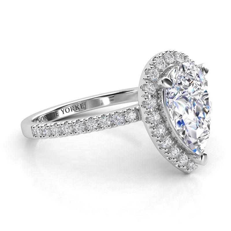 Side view: Dune pear shape cut diamond halo ring with diamonds on the band, created in platinum. 
