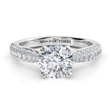 Harper - Front view. Diamond ring in platinum. Centre GIA certified round diamond in a 4 claw setting, double claws. pave set diamonds in 3 rows on the band.