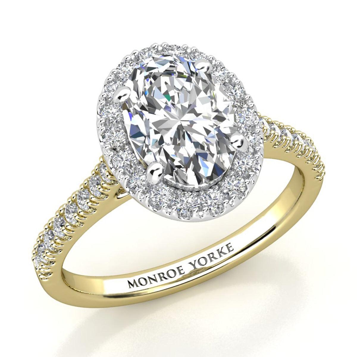 oval cut diamond halo ring in gold. diamond set band. 