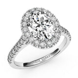 Laurel in platinum: Oval cut diamond halo engagement ring,  diamonds on the sweep up band. 