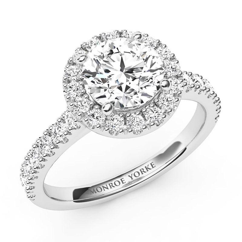 Serene - Round diamond halo engagement ring in platinum.  Diamonds down the sweep up band. Centre GIA certified round diamond. 