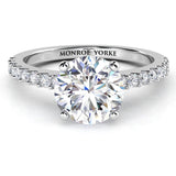 Spring in platinum. Round diamond in a 4 claw centre setting with a diamond set band 