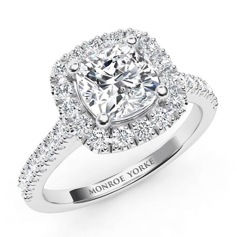 Summer in platinum - centre cushion cut diamond surrounded by a halo of diamonds and diamond on the sweep up band